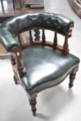 A reproduction captains style armchair, upholstered in green leather