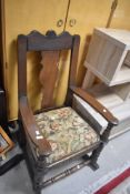 A 19th Century oak rocking chair having vase back, with later upholstered drop in seat, carved