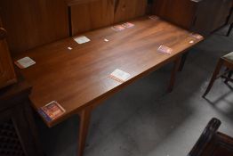 A vintage teak coffee table of stylised design, having fold out top, closed size 140 x 60cm