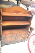 A reproduction Regency style mahogany and walnut wall bookshelf with double cupboard under, width