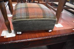 A traditional footstool having dralon and tweed upholstery