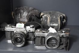 Two Canon AE-1 35mm cameras, one with a Canon FD 35mm f3.5 lens.