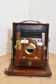A wooden bellows camera with brass fixings. Engraved on the lens mount 'T T & H', probably referring