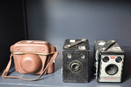 A collection of three Kodak cameras, a Kodak Autosnap camera, a Kodak Brownie Flash III box
