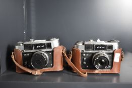 Two FED-4 35mm rangefinder cameras, both with FED 53mm f2.8 lens and brown leather case and strap.