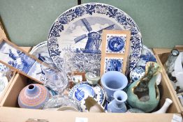 A selection of Delft ware blue and white items including a large display plate and four smaller, a