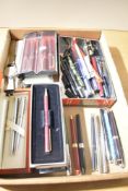 A box of various fountain and ballpoint pens including boxed Sheaffer