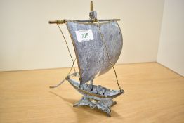 A vintage metal study depicting a Viking style boat, measures 22cm tall.