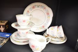 A Susie Cooper bone china tea service, having gilt handles and decorated with floral patterns on a