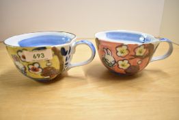 A pair of Japanese style cups hand coloured with Rabbits and calligraphy, h7cm,(2)