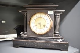 A 19th century black 8 day mantel clock having black Roman numerals on an enamelled chapter ring