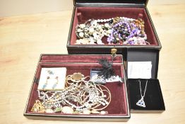 A black faux leather jewellery box, containing a collection of costume jewellery, including