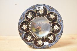 A 19th century Hubert Sattler pottery charger, the centre hand painted depicting a Swiss landscape