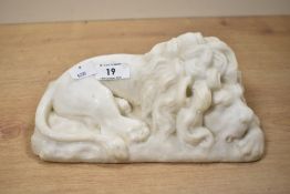 A contemporary carved alabaster sleeping lion statue, in the style of Antonio Canova's lions,