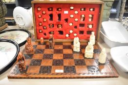 A 20th-century British Museum Isle of Chessmen-style 1:1 set of chess figures with board, stored
