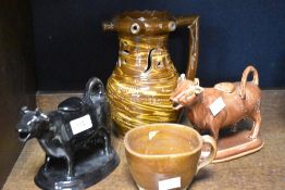 A 19th Century slipware puzzle jug, height approx 21cm, sold with two traditional cow creamers and a