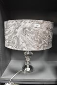 A modern table lamp having floral fabric shade within a sculptural circular globe, h65