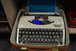 A 1960's Olympia Splendid 33 Type Writer in white, with light brown carry case, instructions