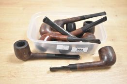 A collection of nine 20th-century briar wood tobacco pipes, including examples by Hardcastle's