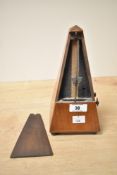A 1930s wooden metronome, unmarked, measuring 22 cm.
