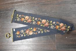 A 20th-century decorative bell pull tapestry with brass hardware, featuring a traditional floral
