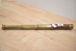 An early 20th-century brass cased three-drawer telescope with wooden grip, unsigned, 42cm at full