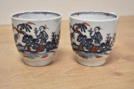 A pair of 18th century English Porcelain cups having a footed base and decorated with figure