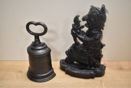Two cast iron doorstops, including 'Judy' from 'Punch and Judy' and a bell-shaped example by