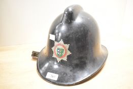 A mid-20th-century Cumbria Fire Service fireman’s helmet, fibreglass shell, with leather chin