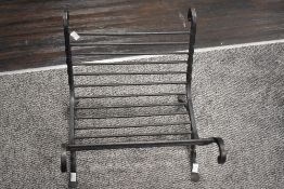 A 20th-century wrought iron fire log holder, with twisted and scrolled details, 37cm in length.
