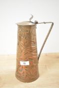 A decorative 20th-century Arts and Crafts copper jug, featuring embossed floral scroll work