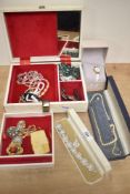 A cream faux leather jewellery box, containing an assortment of costume jewellery including