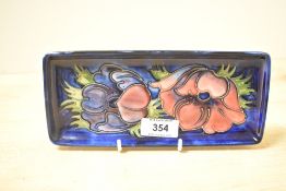 A 20th-century Moorcroft pottery Anemone pattern pen tray, featuring a dark cobalt blue