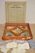 A vintage French Nain Jaune ('Yellow Dwarf') game set stored in an orange-coloured wooden box, to