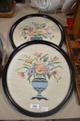 A set of two early 20th-century floral cross-stitch pictures in oval wooden frames, 38cm, (2),