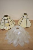 Two 20th-century Tiffany pendant-style lampshades, featuring a geometric pattern in cream and
