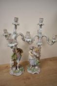 A pair of 19th-century porcelain four-branch candelabra, depicting male and female figurines with
