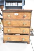 A 20th-century mahogany tabletop chest of drawers, featuring a caddy top, four graduated drawers