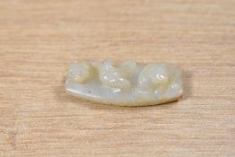 A Chinese carved green stone pendant/amulet, featuring floral motifs on both sides and an animal