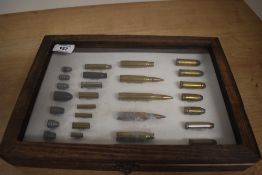 A display case of inert pistol and rifle rounds including .44 Magnum, .45 ACP, .375 Magnum and a .38