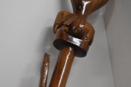An oriental style wooden carved walking stick with a carved Elephant just below the handle and a