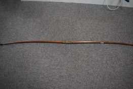 An unstrung wooden long bow