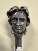 A walking cane with a white metal gentlemen's head as the handle measuring measuring 94cm. The