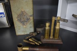 A vintage pellet tin and a vintage pellet tin along with a small powder shot tool and a bullet