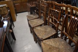 A set of three 19th Century rush seated dining chairs having spindle backs and a similar rail back
