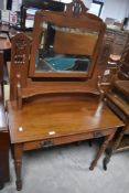 A late 19th/early 20th century mahogany dressing table, with central pivoted and bevelled mirror