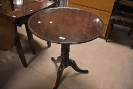 A Victorian mahogany pedestal occasional table having lip to circular with turned column and