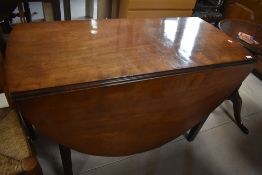 A late 19th or early 20th Century mahogany dining table having oval drop leaves on square double
