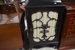 An Edwardian stained and glazed mahogany music cabinet, having a shaped surmount over a glazed