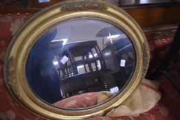 A vintage gilt frame wall mirror of oval form with foliate relief decoration , approx. 60 x 51cm